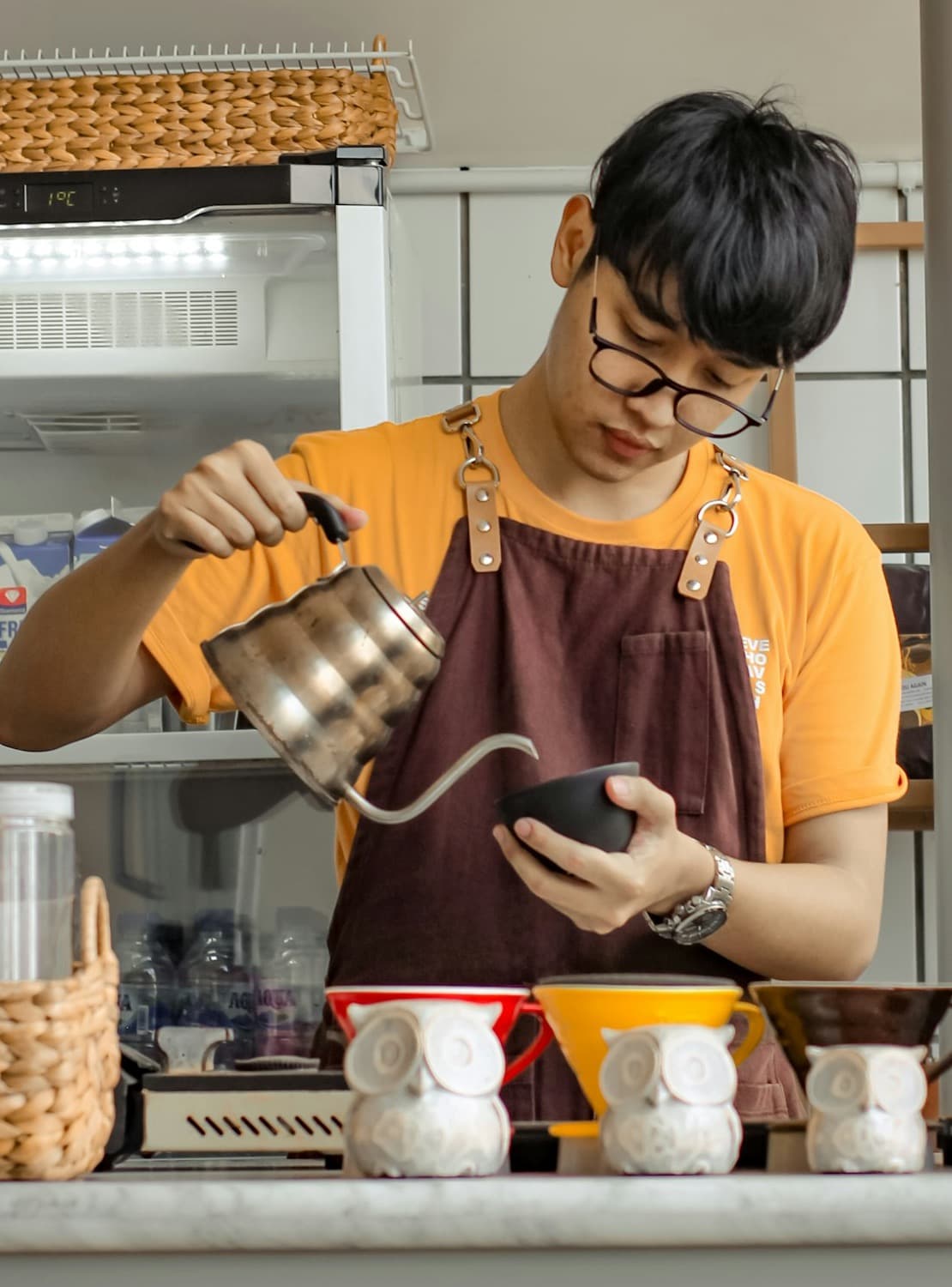A barista pouring coffee at a café counter